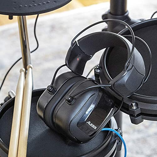 Headphones resting on an electronic drum set.