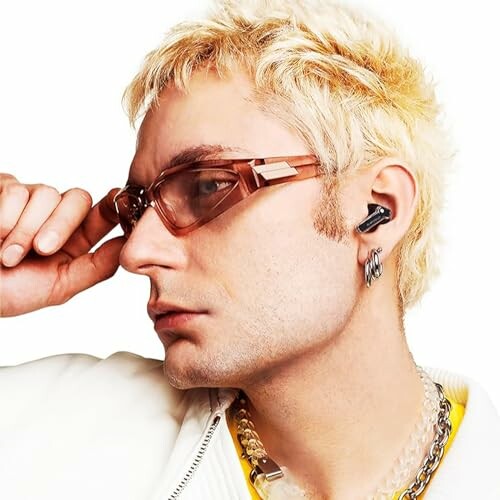 Man with blonde hair, sunglasses, and earbud.