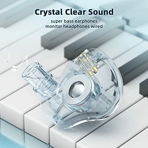 Transparent earphones on piano keys with text 'Crystal Clear Sound'.